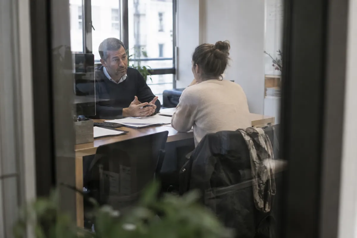 Conseiller et cliente en entretien dans un bureau — image d’ambiance générée par IA